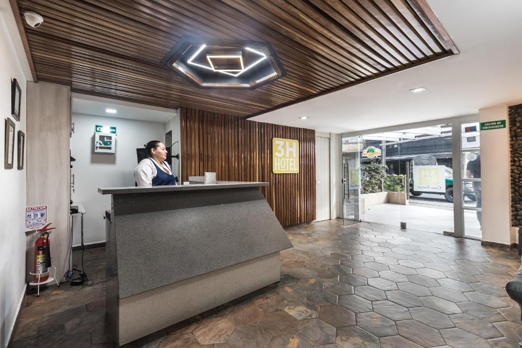 a woman standing at a counter in a lobby at Casa Hotel Solare de la 70 in Medellín