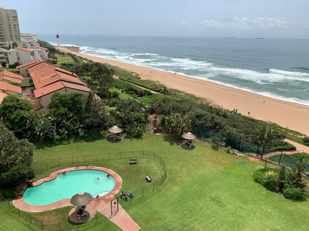 an aerial view of a swimming pool and the beach at 71 Kyalanga in Durban