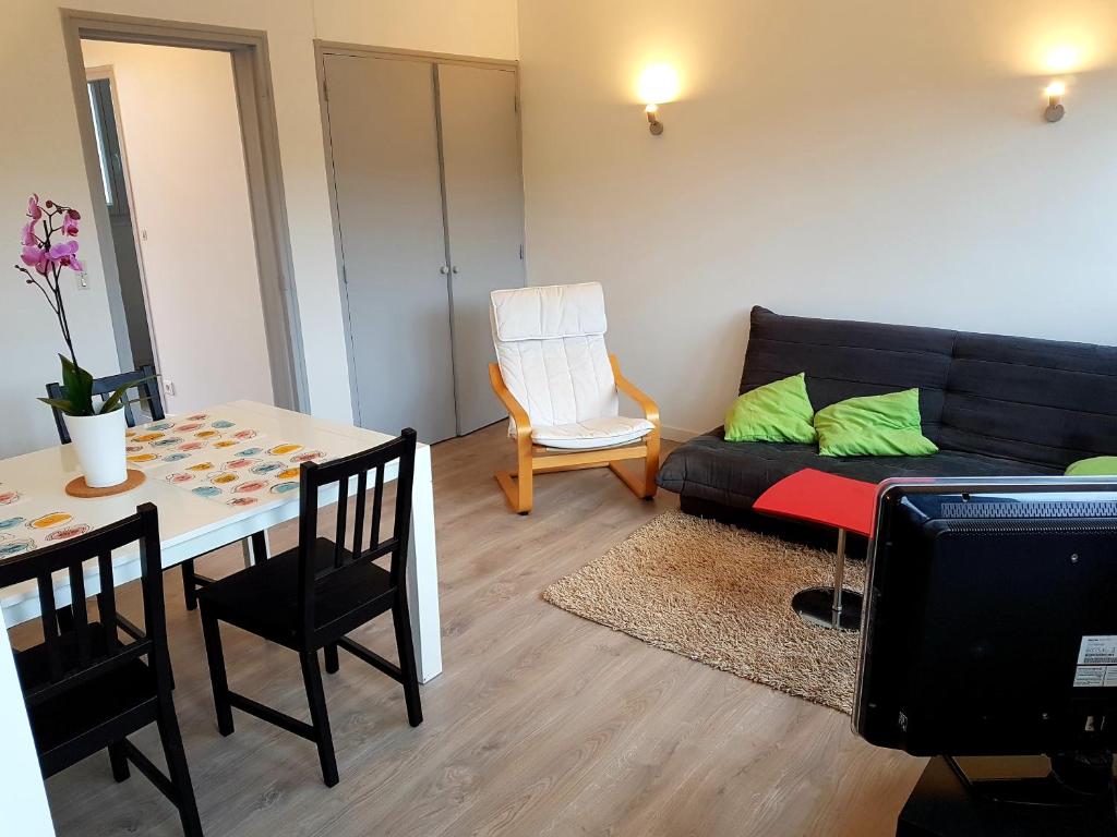 a living room with a couch and a table at Appartement rénové lumineux proche centre ville in Louviers