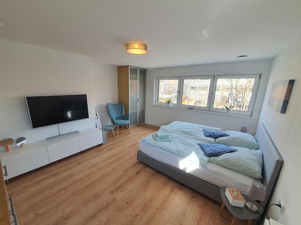 een slaapkamer met een bed en een flatscreen-tv bij Fröbelnest in Filderstadt