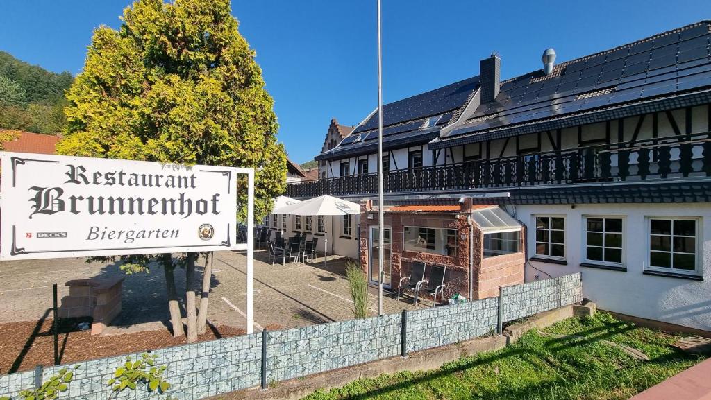 un bâtiment avec un panneau devant lui dans l'établissement MATZ Brunnenhof, à Wilgartswiesen