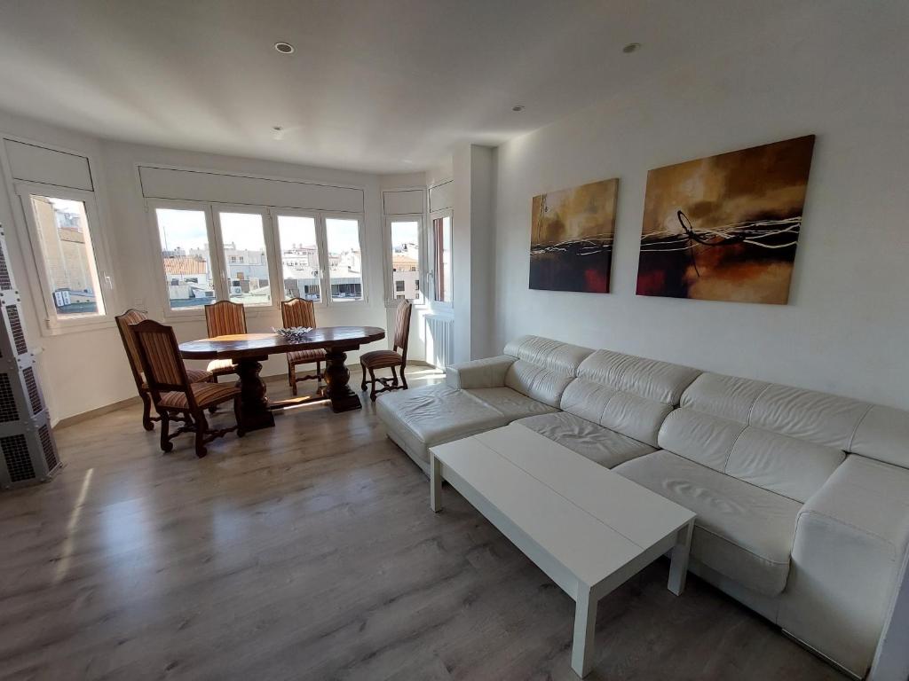 sala de estar con sofá blanco y mesa en Àtic al centre de Girona, en Girona