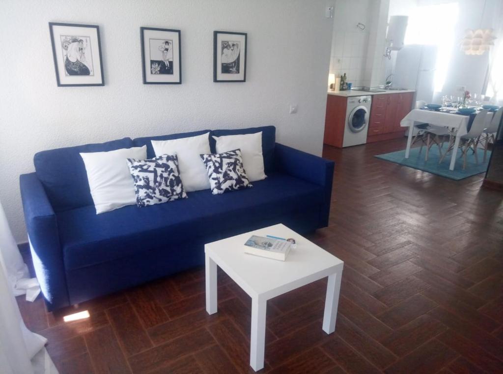 sala de estar con sofá azul y mesa en Céntrico apartamento de dos dormitorios, amplio y luminoso en Plasencia