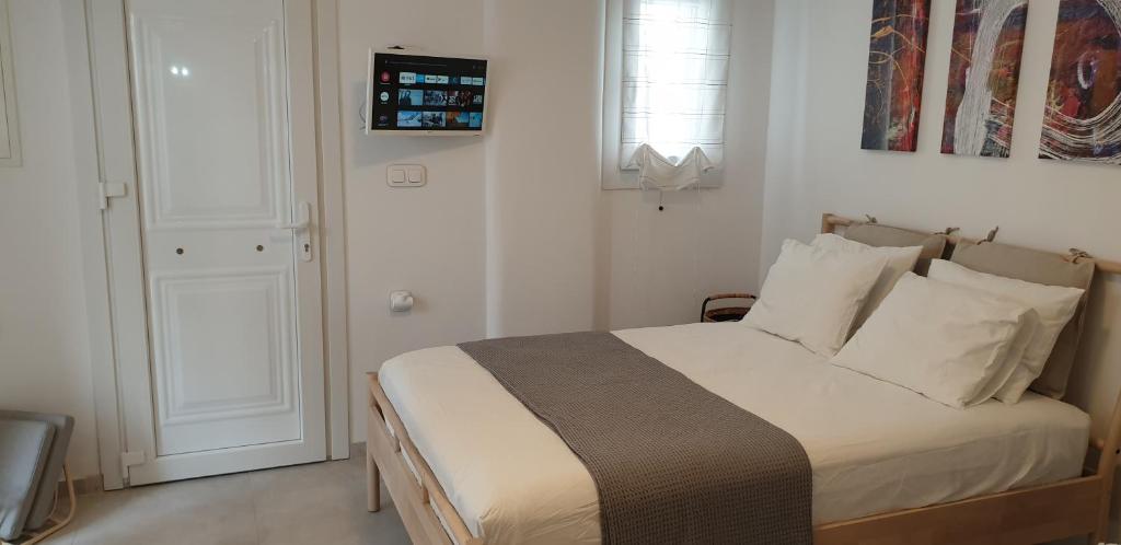 1 dormitorio con cama, ventana y puerta en La Playa Studio Mykonos, en Platis Gialos