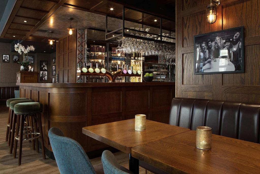a bar with a wooden table and chairs at Bergen Harbour Hotel, WorldHotels Crafted in Bergen