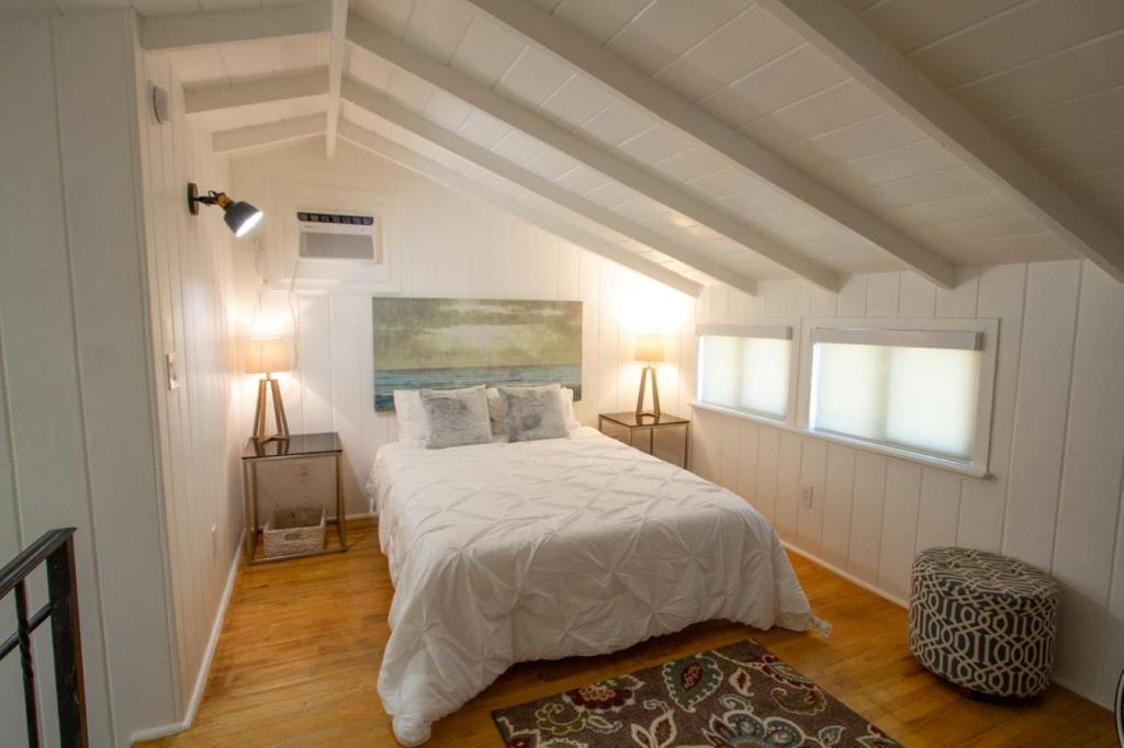 a white bedroom with a bed and two lamps at Peaceful Getaway in Studio City in Los Angeles