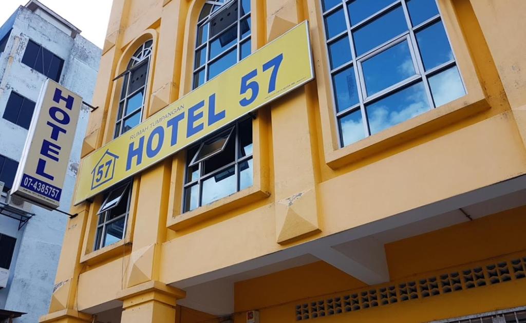 un edificio amarillo con un cartel de hotel en Fifty Seven Inn, en Batu Pahat