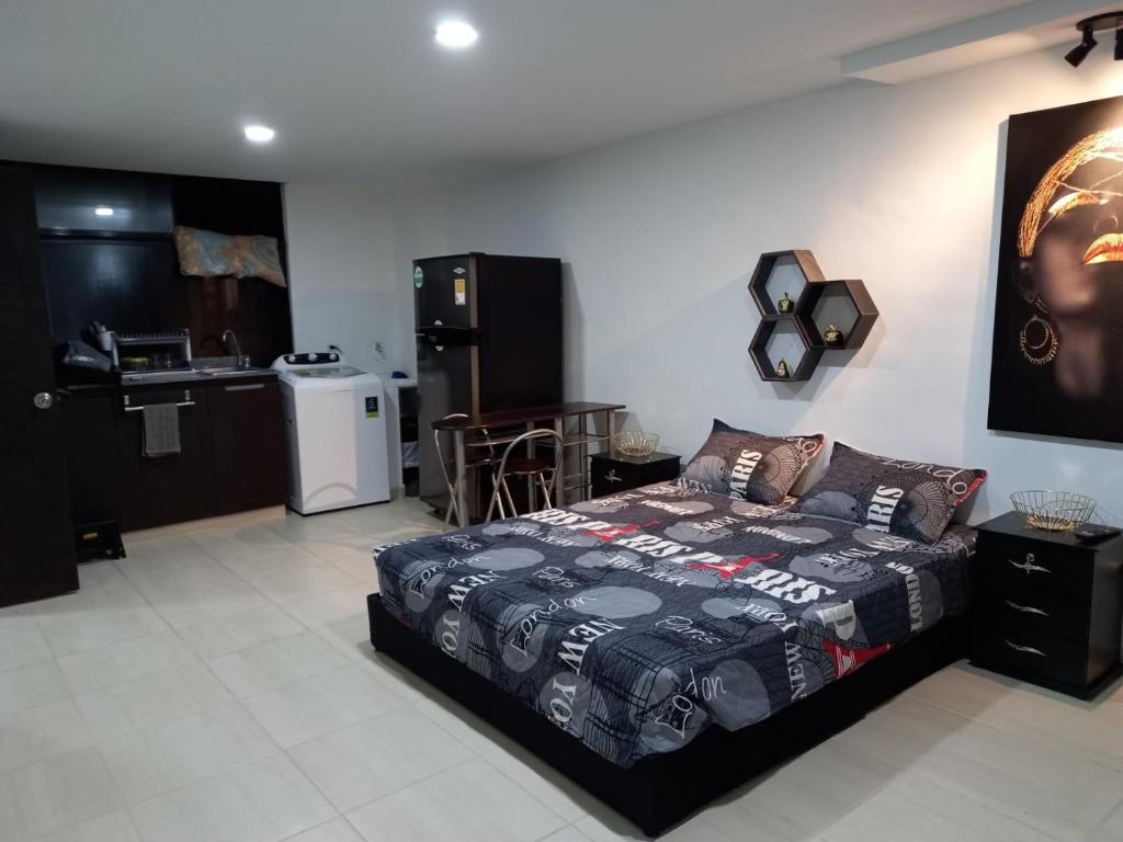 a bedroom with a bed and a kitchen in a room at Apartamento tipo Loft in Medellín
