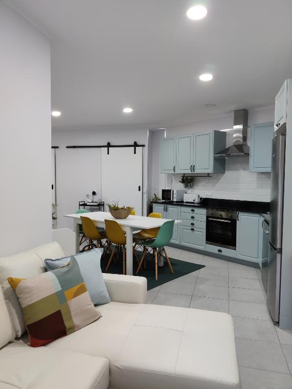 a living room with a white couch and a kitchen at Riviera Beach AL in Praia da Vitória