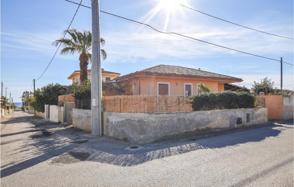 una casa al lado de una calle con una pared en Nice Home In Marina Di Modica With Wifi, en Marina di Modica