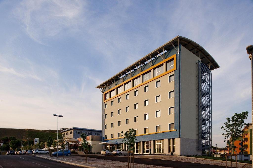 a tall white building with a curved roof at Blu Arena Hotel in Montecchio