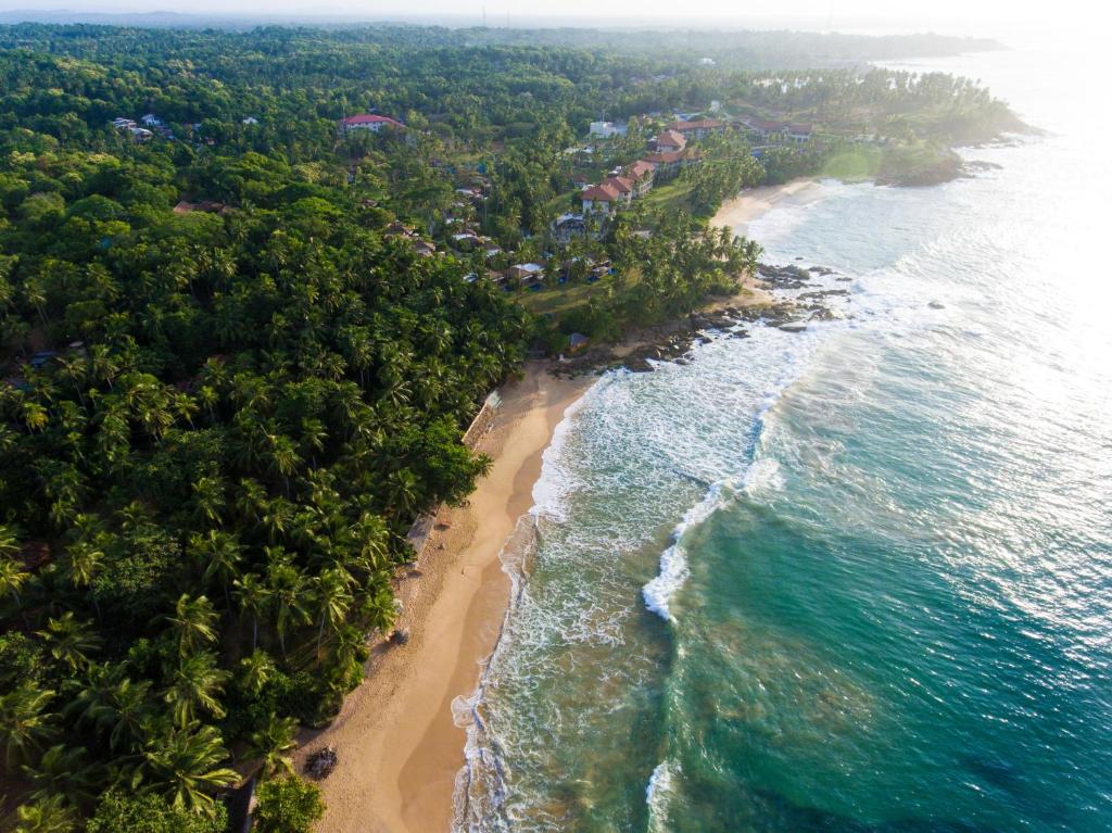 an aerial view of a beach and the ocean at Palm Paradise Cabanas & Villas Beach Resort in Tangalle