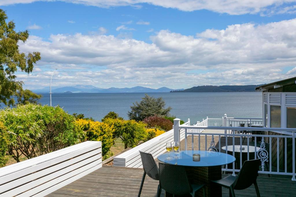 a balcony with a table and chairs and a view of the water at VU Thermal Lodge - ADULTS ONLY MOTEL in Taupo