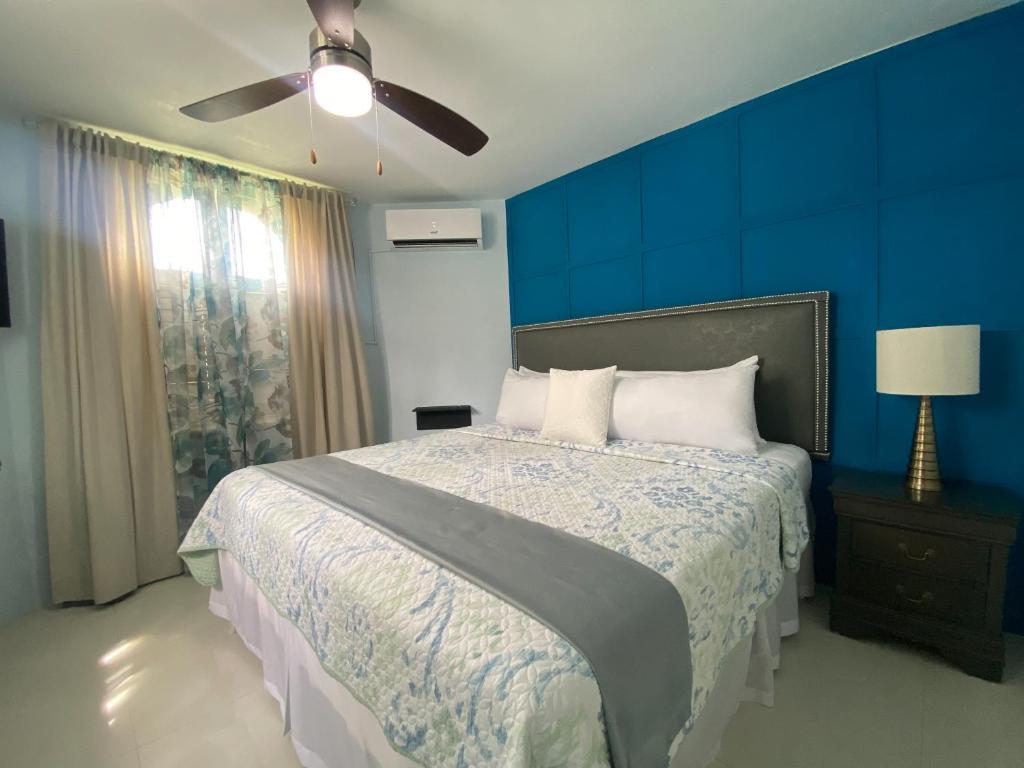 1 dormitorio con 1 cama con pared azul en Ocho Rios Sandcastles A19, en Ocho Ríos