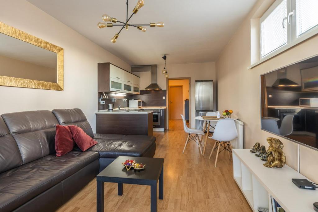 uma sala de estar com um sofá e uma mesa em Apartmán v Aleji em Bratislava