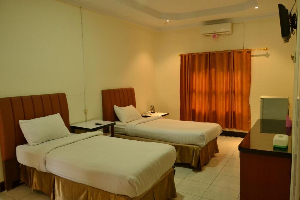 Postel nebo postele na pokoji v ubytování Malibou Hotel Medan