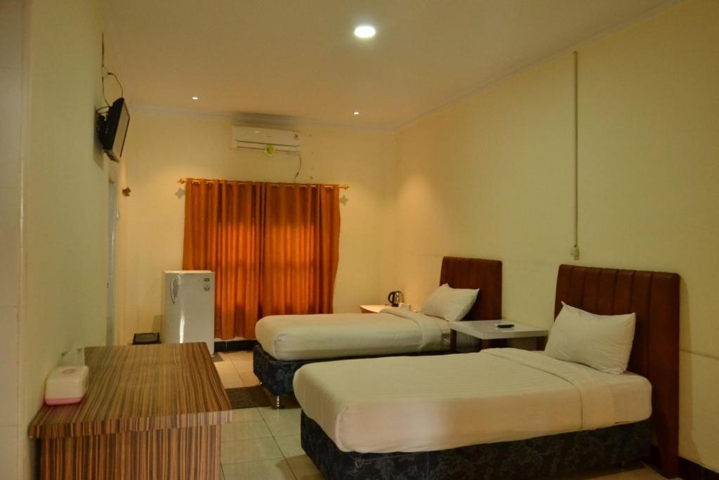 Postel nebo postele na pokoji v ubytování Malibou Hotel Medan