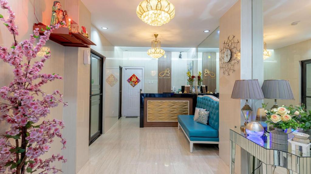een woonkamer met een blauwe bank en een blauwe stoel bij Baymont Suites & Residences in Manilla