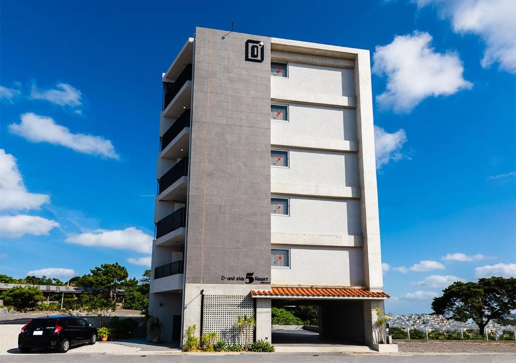 een hoog gebouw met de letter o erop bij D-and Stay 5 Resort Okinawa in Urasoe