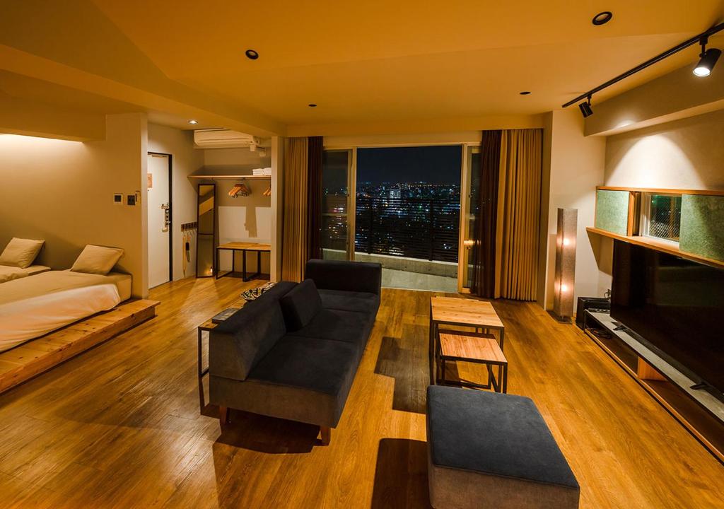 a large living room with a couch and a television at D-and Stay 5 Resort Okinawa in Urazoe