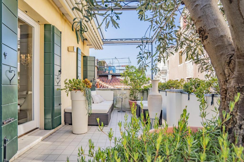 patio z kanapą i roślinami w obiekcie Colleoni Apartment with 2 Superb Terraces w Wenecji