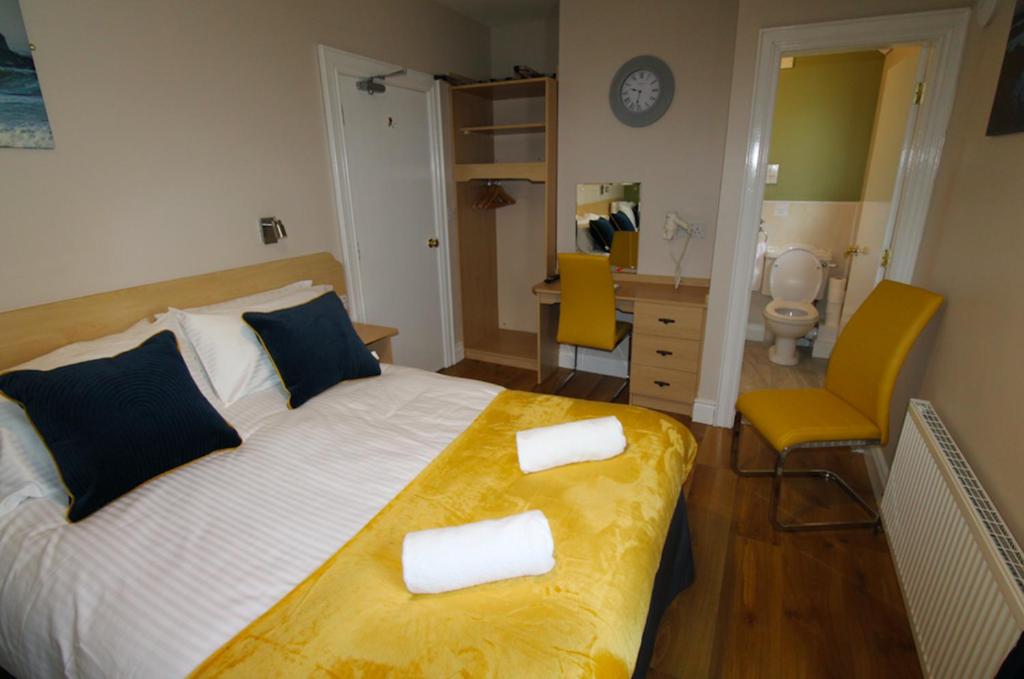 a bedroom with a bed with two towels on it at Beulah Guest House in Portrush