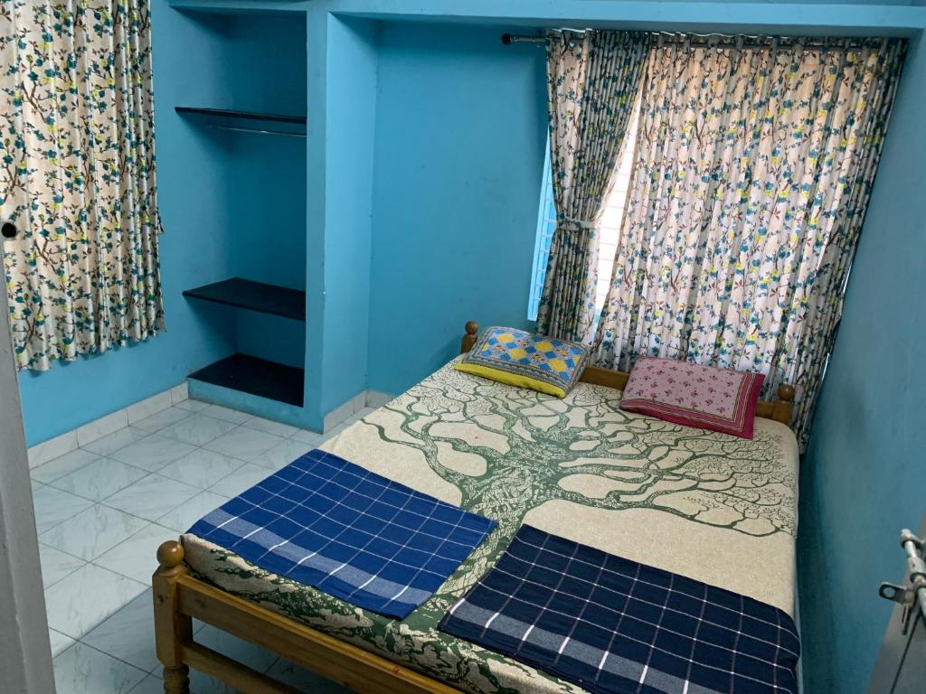 um quarto com uma cama com uma colcha de árvore em Harbour town holiday home -malpe em Malpe