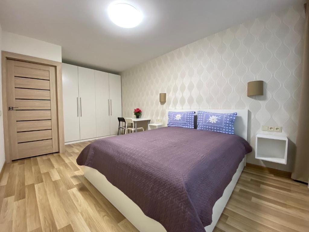 a bedroom with a large bed and a table at Stay in Kaunas! Brand new, 2 rooms in Kaunas