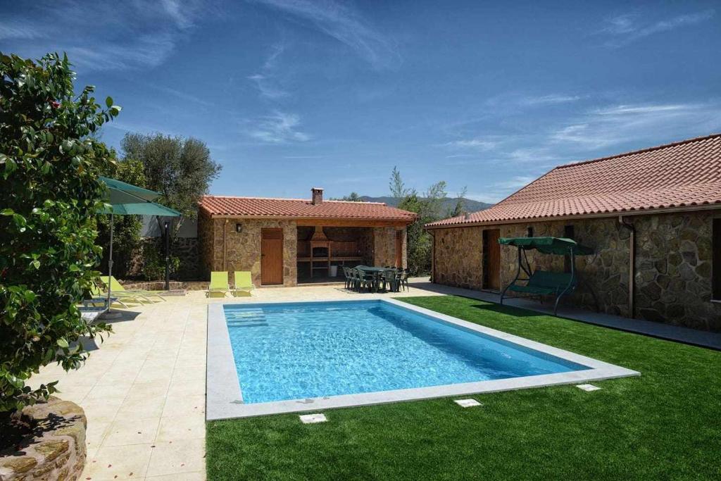 a swimming pool in a yard next to a house at Casa do Tanque Camélias de Basto in Celorico de Basto