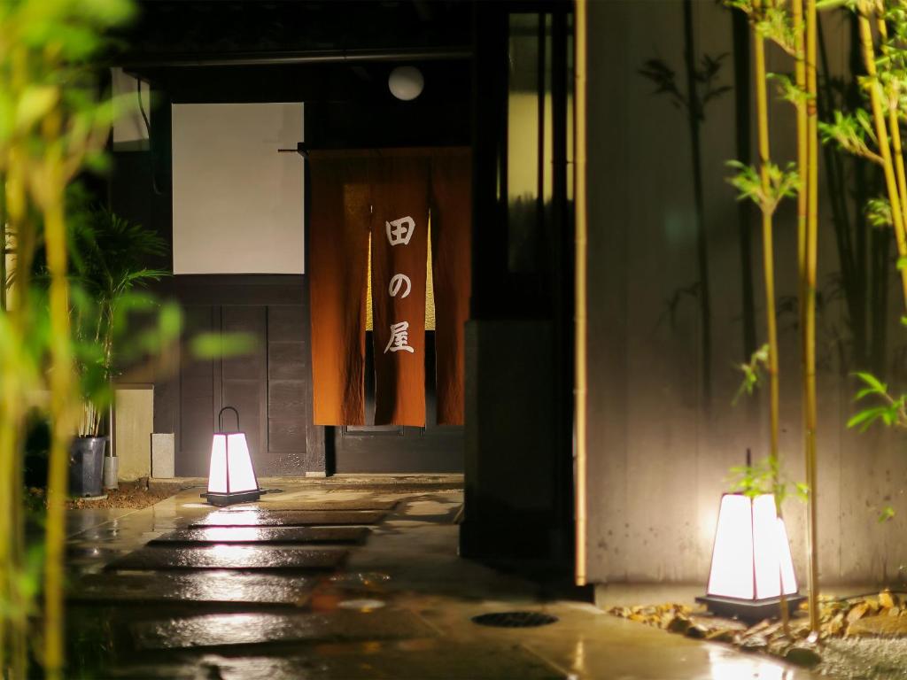 two lights on a walkway in front of a building at Ryokan Tanoya in Kyoto