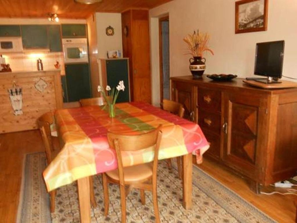 uma sala de jantar com uma mesa e algumas cadeiras em La Tour em Combloux