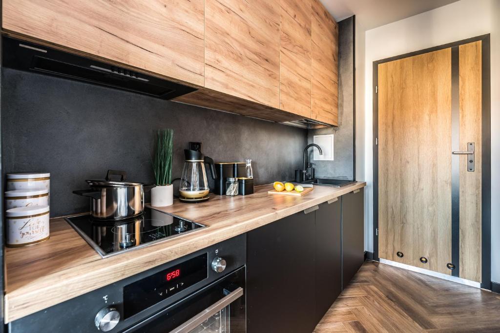 una cucina con stufa nera e armadietti in legno di Hexagon Studio a Breslavia