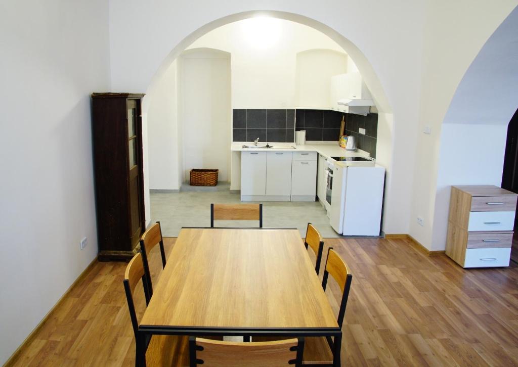 cocina con mesa de madera y sillas en Apartment Porta en Terezín