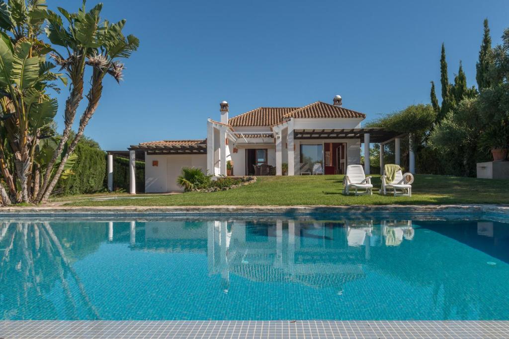 a villa with a swimming pool in front of a house at Villa Violeta in Benalup Casas Viejas
