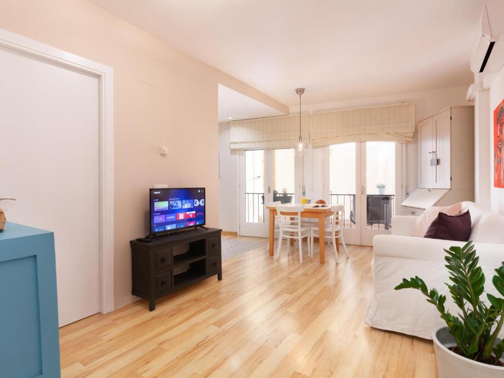 a living room with a couch and a tv on a table at LETS HOLIDAYS Attractive apartment in costa brava in Tossa de Mar