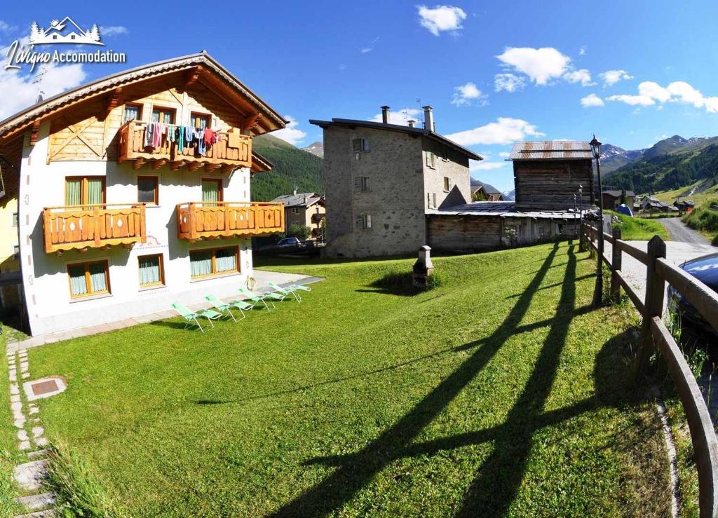 リヴィーニョにあるAlpen Royal raggiungibile con gli sci ai piediの家と柵のある広い庭