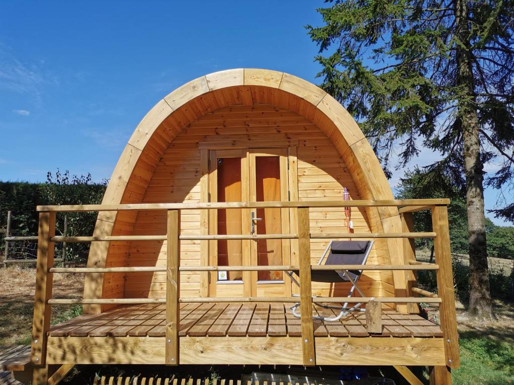 una sauna de madera con una puerta redonda en una terraza en La Cabane Insolite en Puy-du-Fou