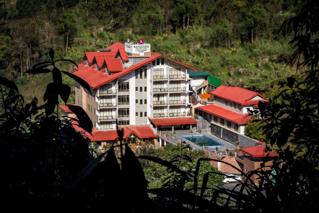 un gran edificio con techo rojo y piscina en Yashshree Kanishka en Gangtok