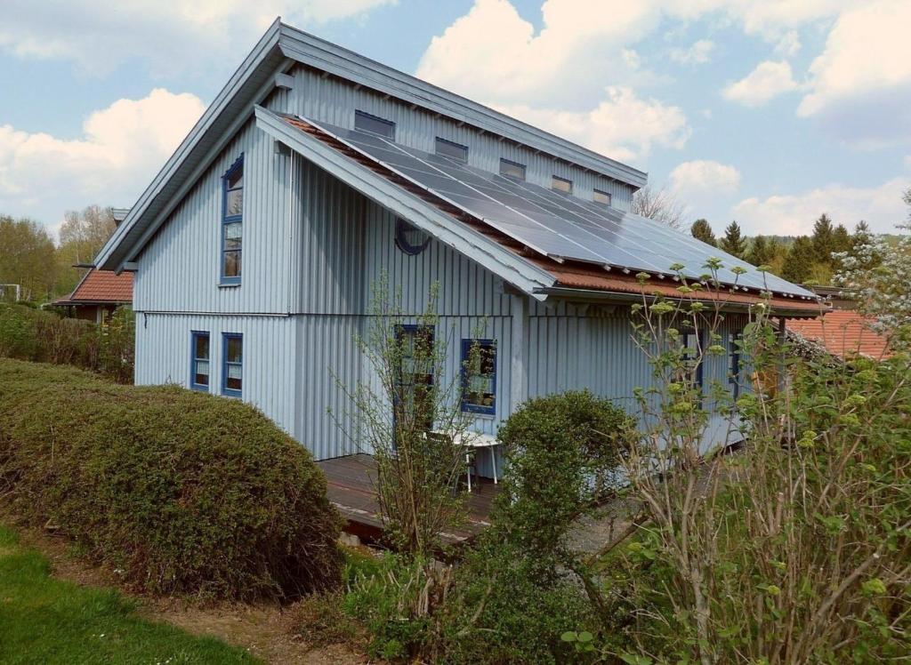 una casa blanca con techo de metal en Ferienhaus Nr 9A3, Feriendorf Hagbügerl, Bayr Wald en Waldmünchen