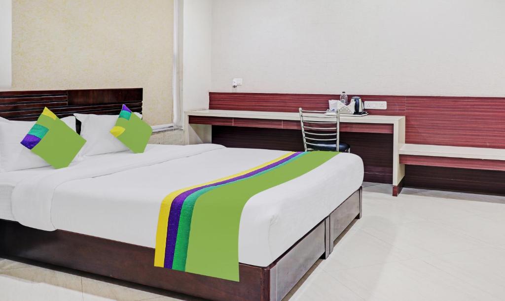 a bedroom with a large bed and a desk at Treebo Trend Elite City Upper Bazar in Rānchī