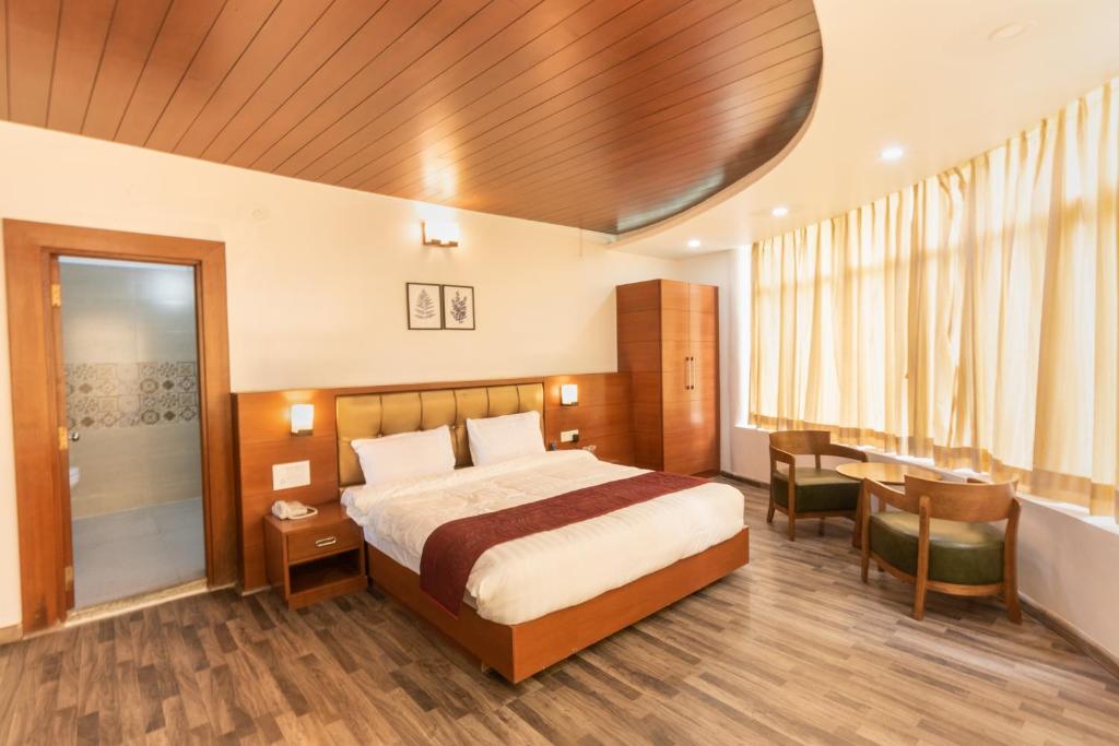 a hotel room with a bed and a desk at Himalayan Splendour Resort in Dhanaulti