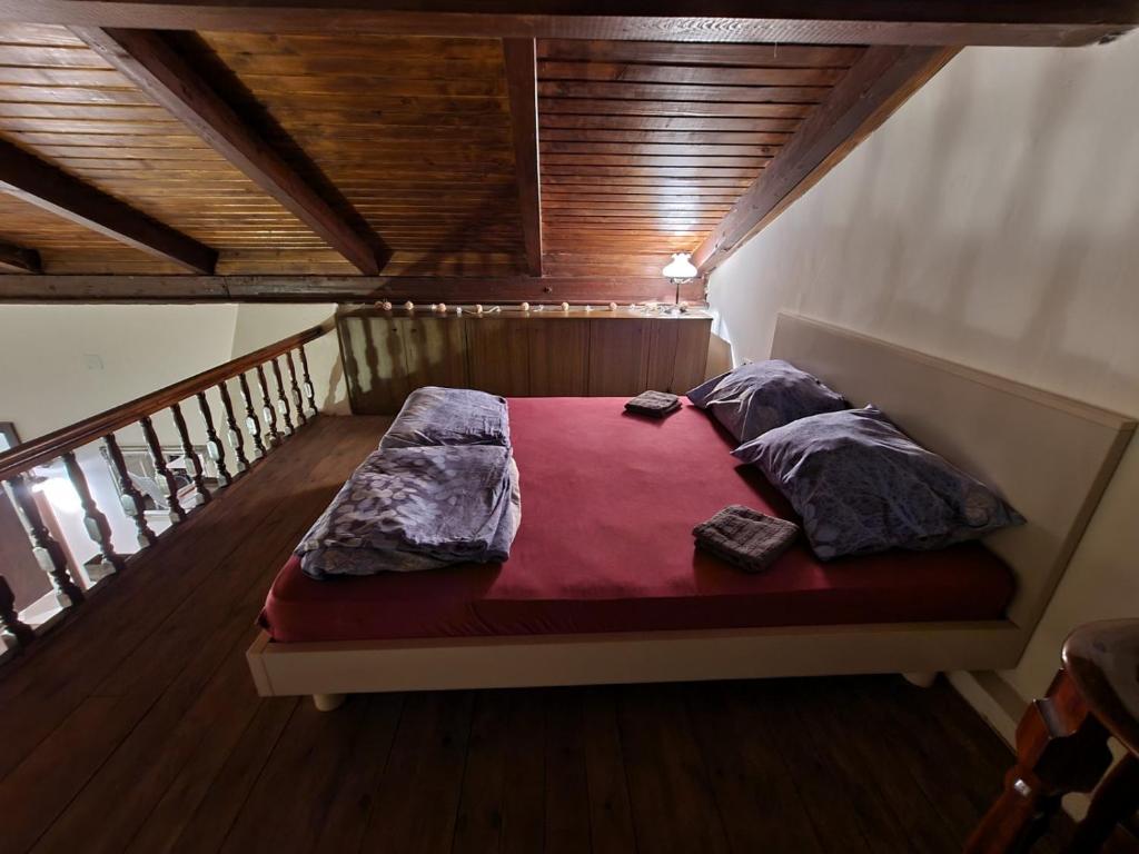 a bed in a room with a wooden ceiling at MilBor Fruška Gora in Novi Sad