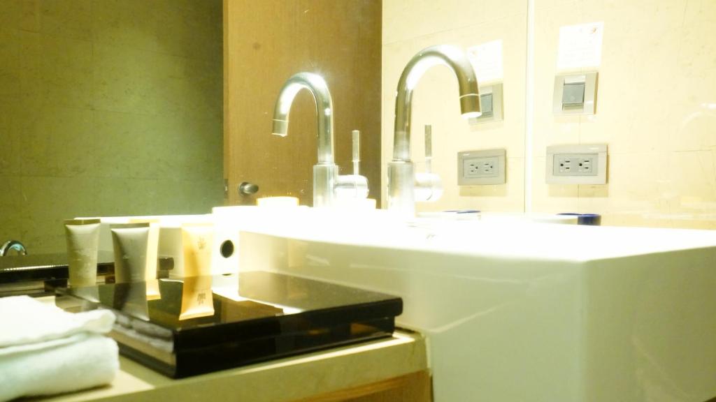 a bathroom with two sinks and two mirrors at City Suites-Taipei Nanxi in Taipei