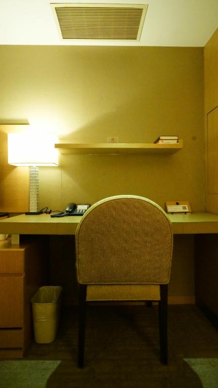 a desk with a chair and a lamp in a room at City Suites-Taipei Nanxi in Taipei