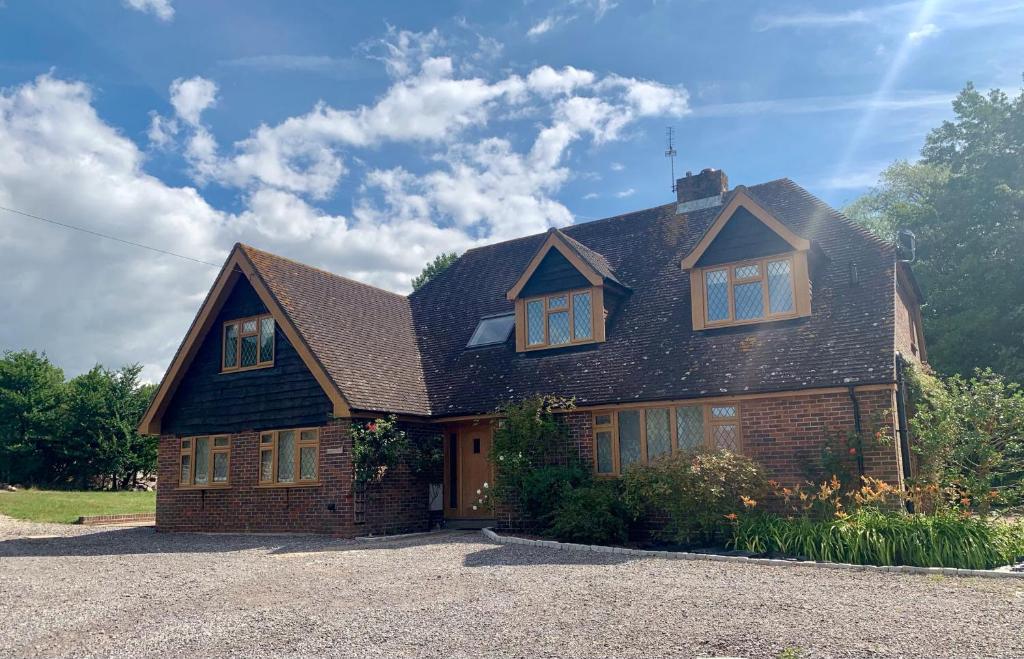 een bruin bakstenen huis met een gambrel dak bij Brackenside , Angmering in Angmering