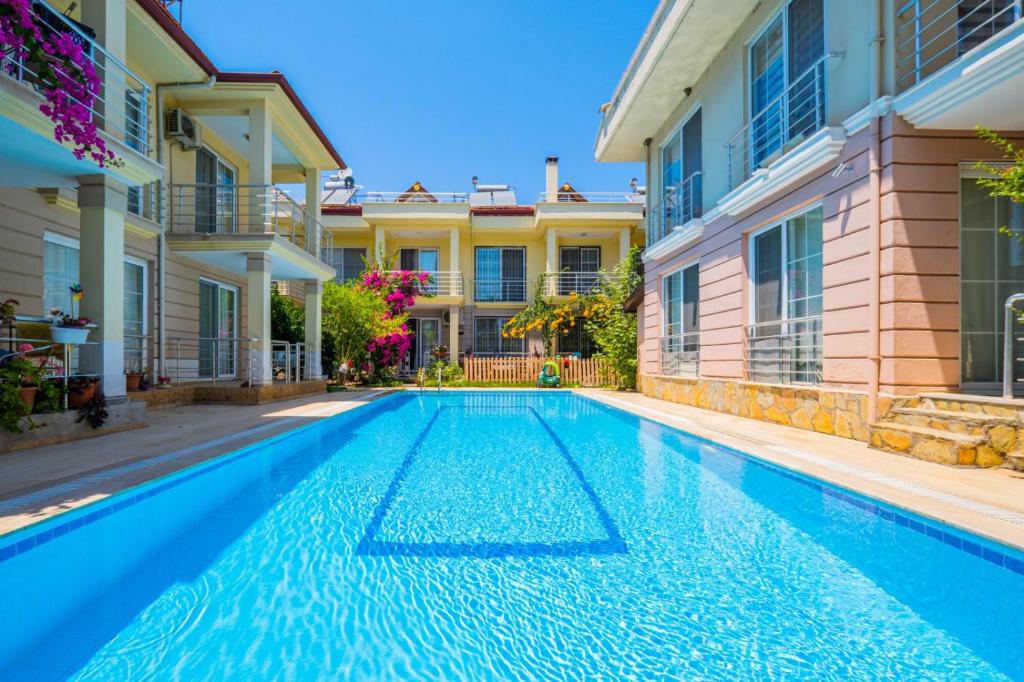 a swimming pool in front of a house at Gül Evleri Çalış Beach Villa in Fethiye