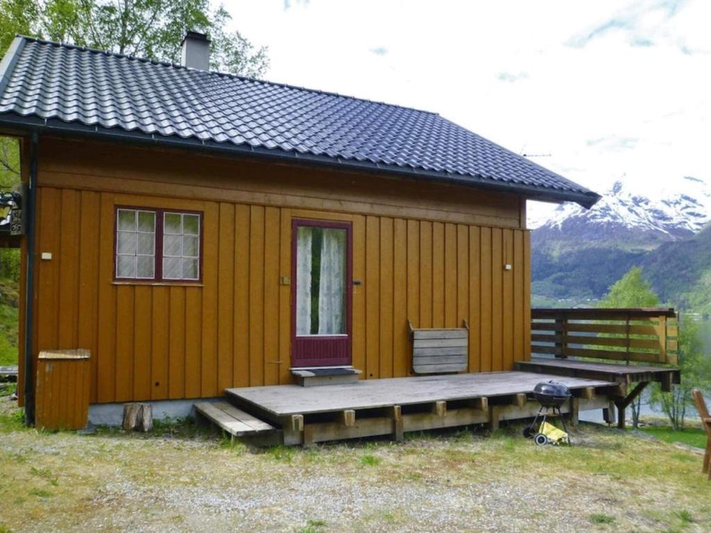 a small wooden cabin with a porch and a bench at 7 person holiday home in STRYN-By Traum in Stryn
