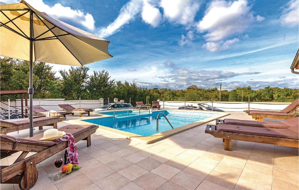 basen z ławkami i parasolem w obiekcie Holiday Home Marcana 57 w mieście Marčana