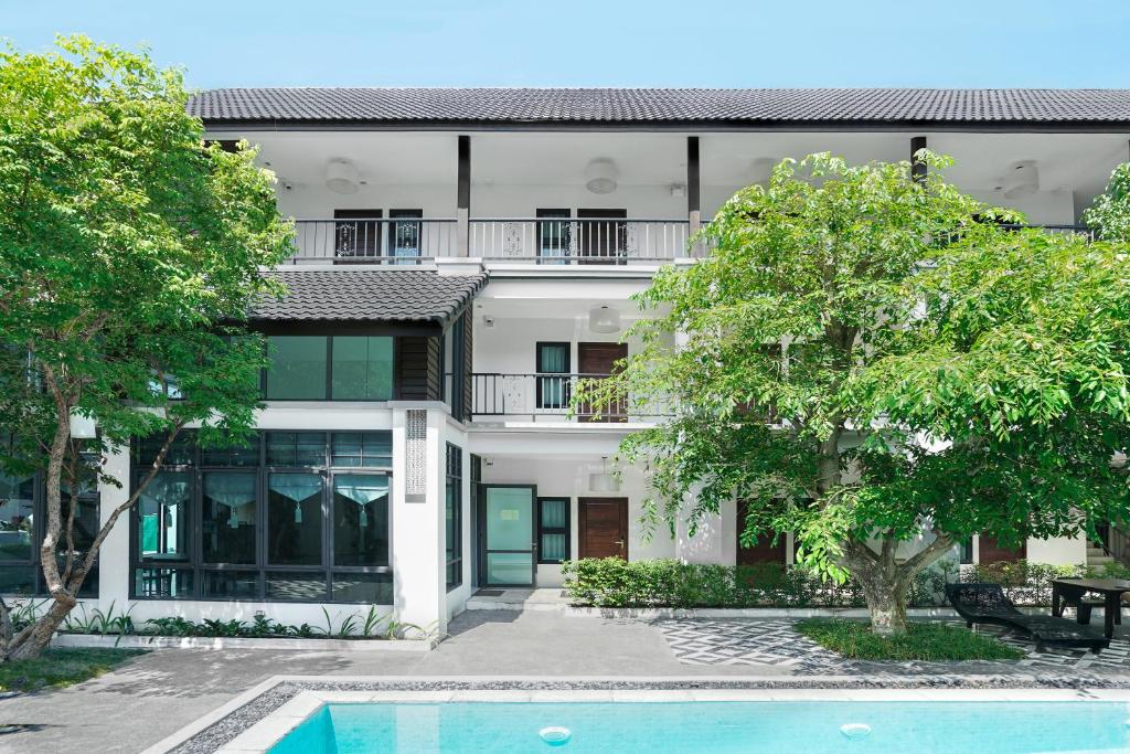 an apartment building with a swimming pool in front of it at Paraiso Hotel Chiangmai in Chiang Mai