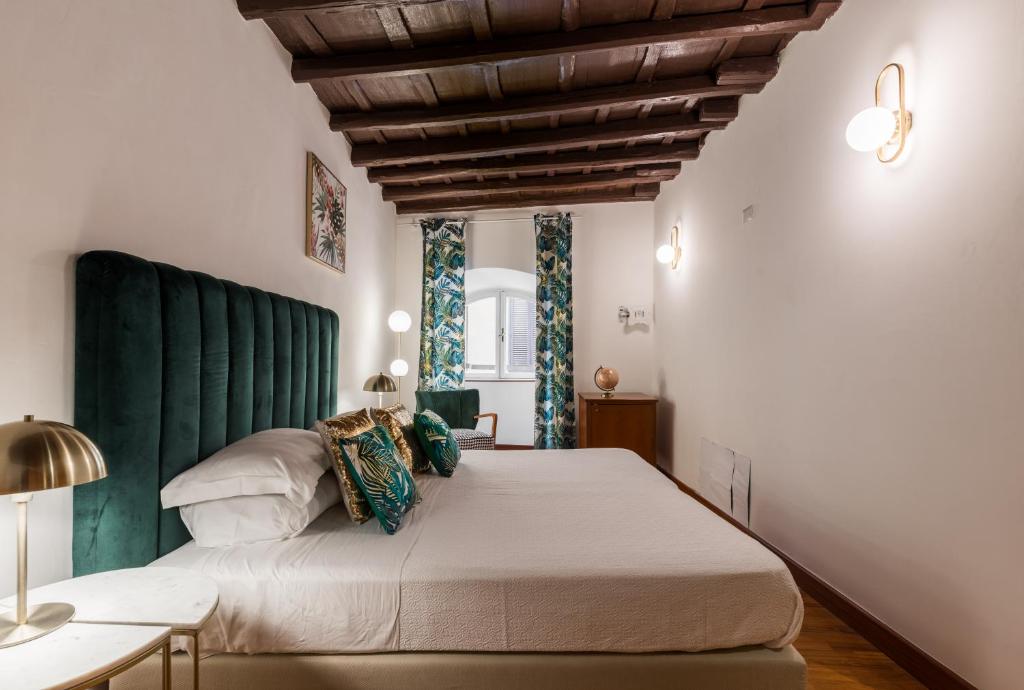 a bedroom with a large bed with a green headboard at Bernini Collection in Rome